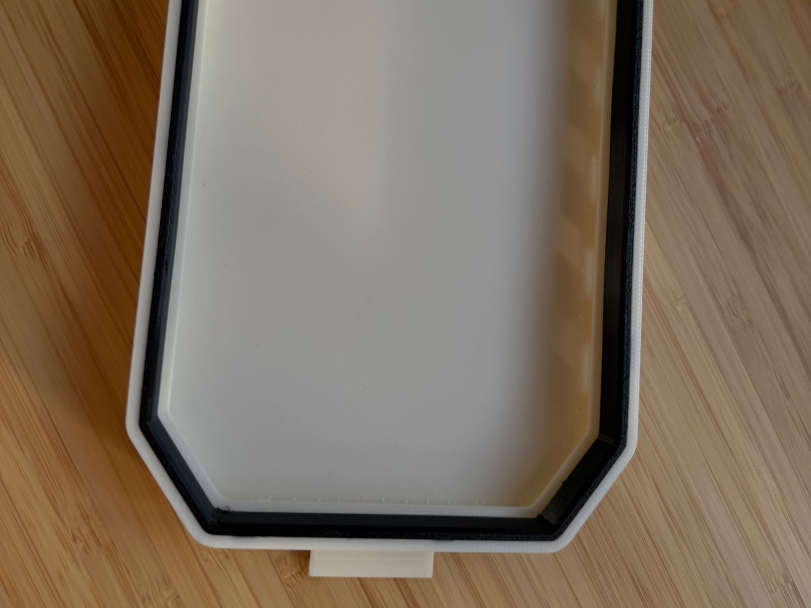 The underside of the dash cover showing the black TPU 85A seal frame bonded around the inside of the white ASA shell.