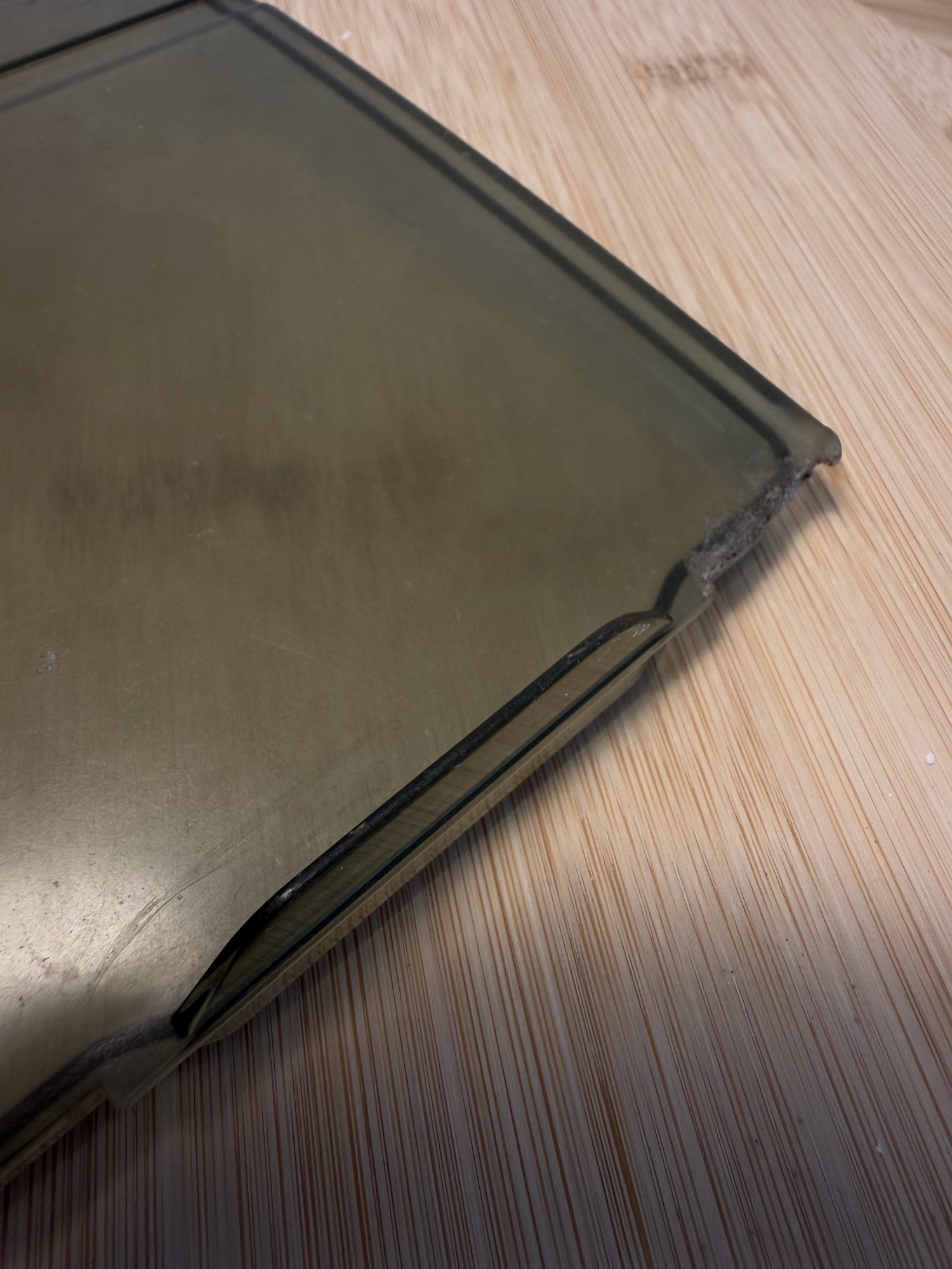Close-up of the original lid's corner, cracked through the edge.