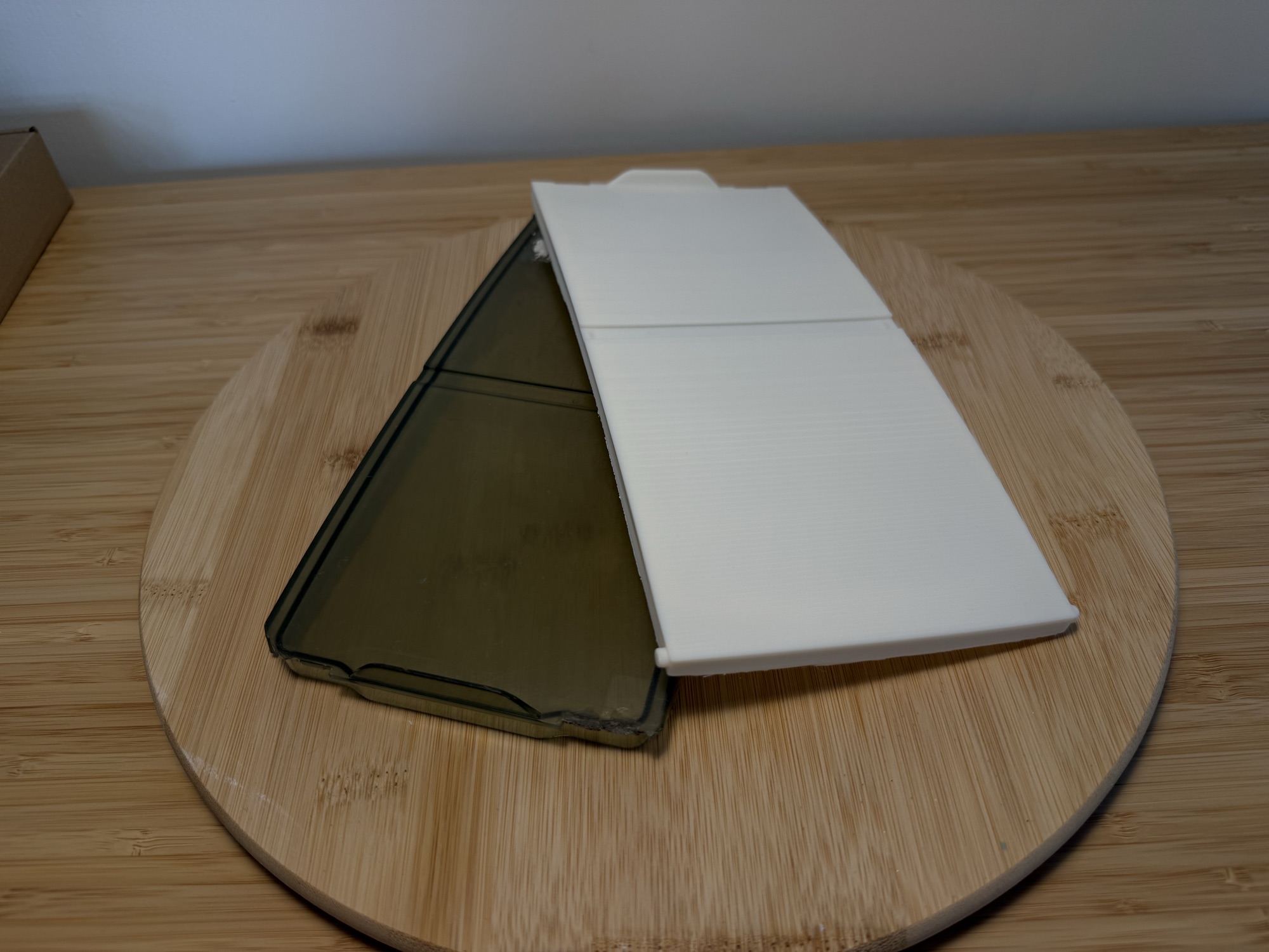 The new white lid and the original smoked lid side by side on a wooden board.