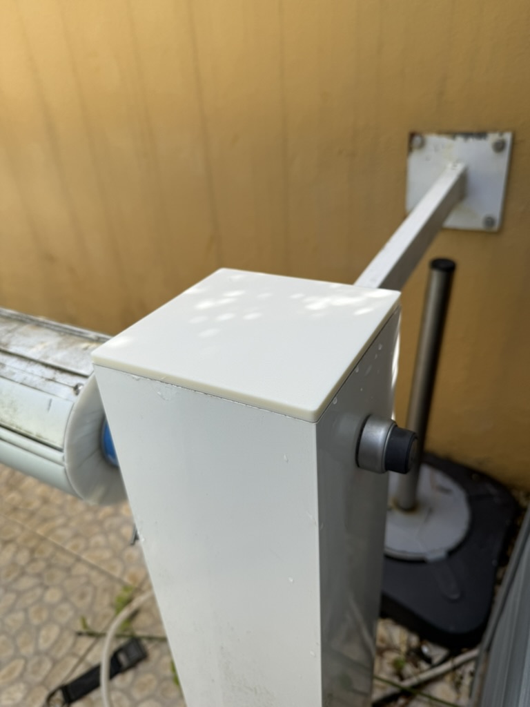 A new cap on a reel post, seen with the support arm and the wall bracket behind.